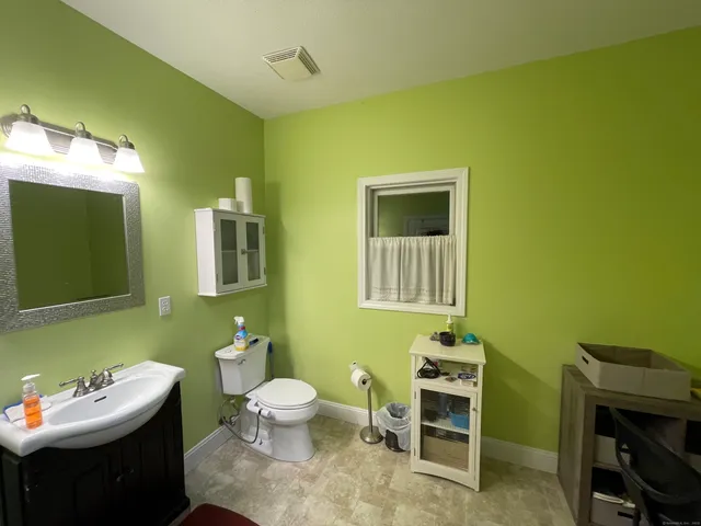 a bathroom with a sink mirror vanity and toilet