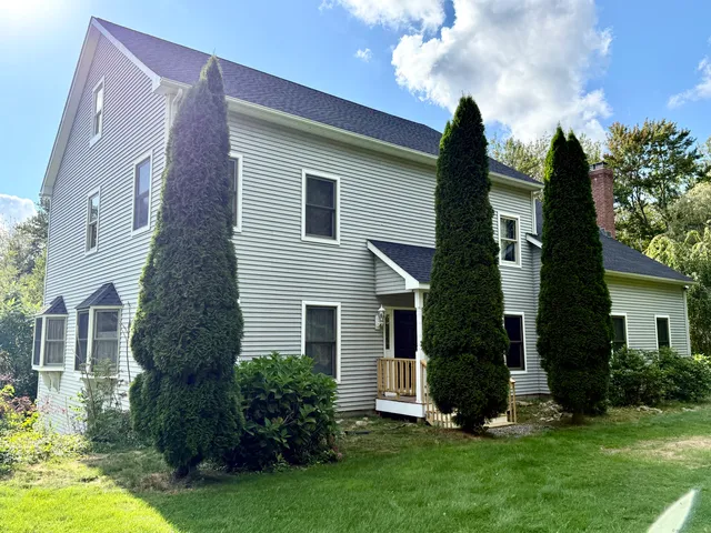 a front view of a house with a garden and plants