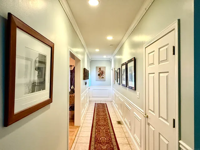 a view of a hallway with wooden floor and windows