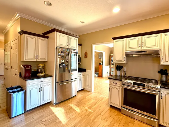a kitchen with stainless steel appliances a stove a refrigerator and a sink