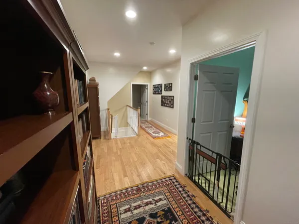 a view of a hallway with wooden floor and staircase