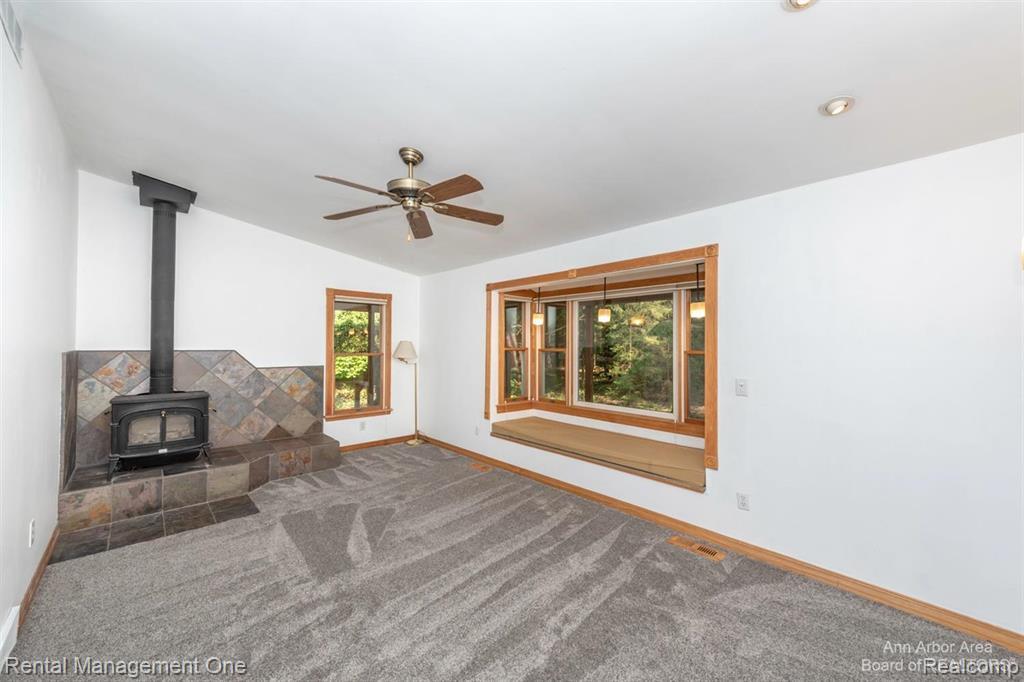 7870 Chamberlin Road Dexter, MI 48130 - Photo 14 of 52 Wood-burning stove with a tiled hearth and wall surround