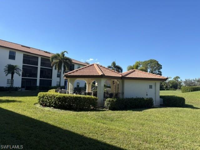 605 Augusta Boulevard, Unit 4 Naples, FL 34113 - Photo 24 of 25 a front view of a house with a yard