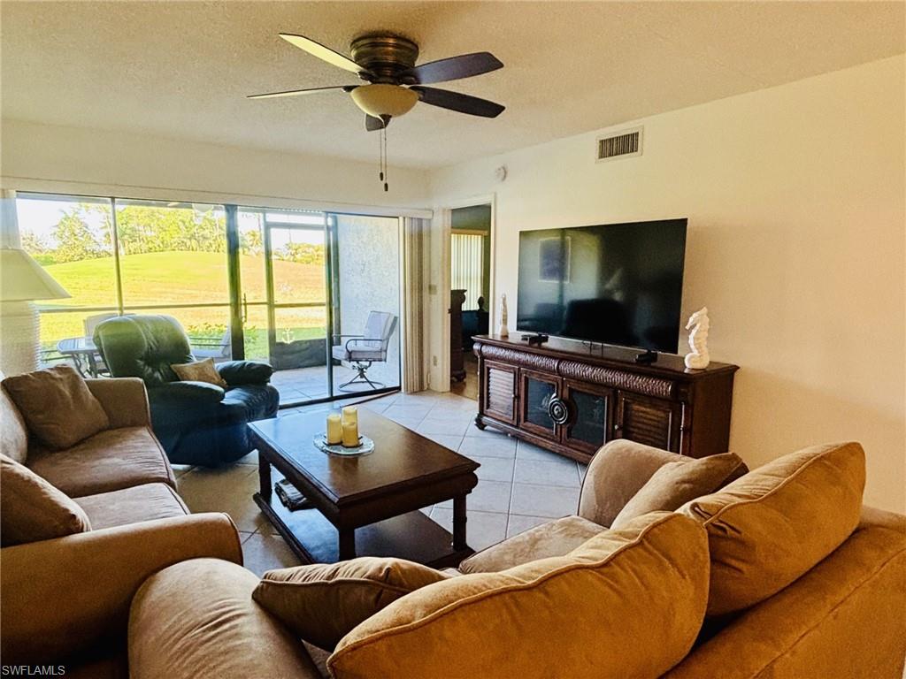 605 Augusta Boulevard, Unit 4 Naples, FL 34113 - Photo 4 of 25 a living room with furniture and a flat screen tv