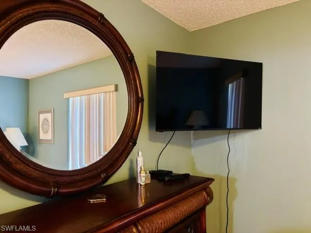 a bedroom with a bed a mirror and a window