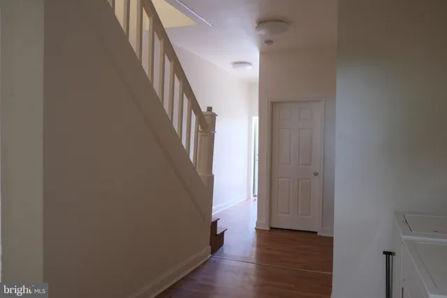 a view of a hallway with wooden floor and staircase