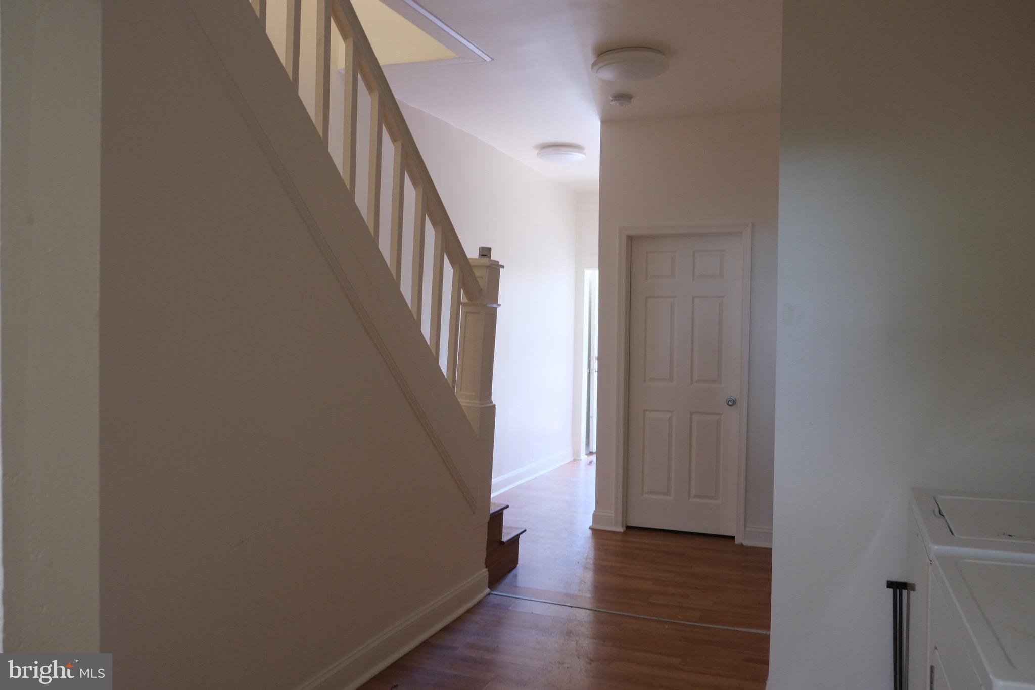 3316 West Belvedere Avenue Baltimore, MD 21215 - Photo 17 of 19 a view of a hallway with wooden floor and staircase