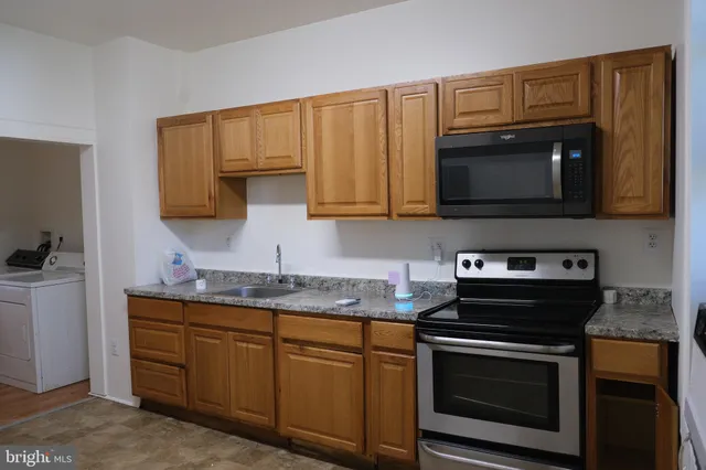 a kitchen with granite countertop a stove microwave and sink