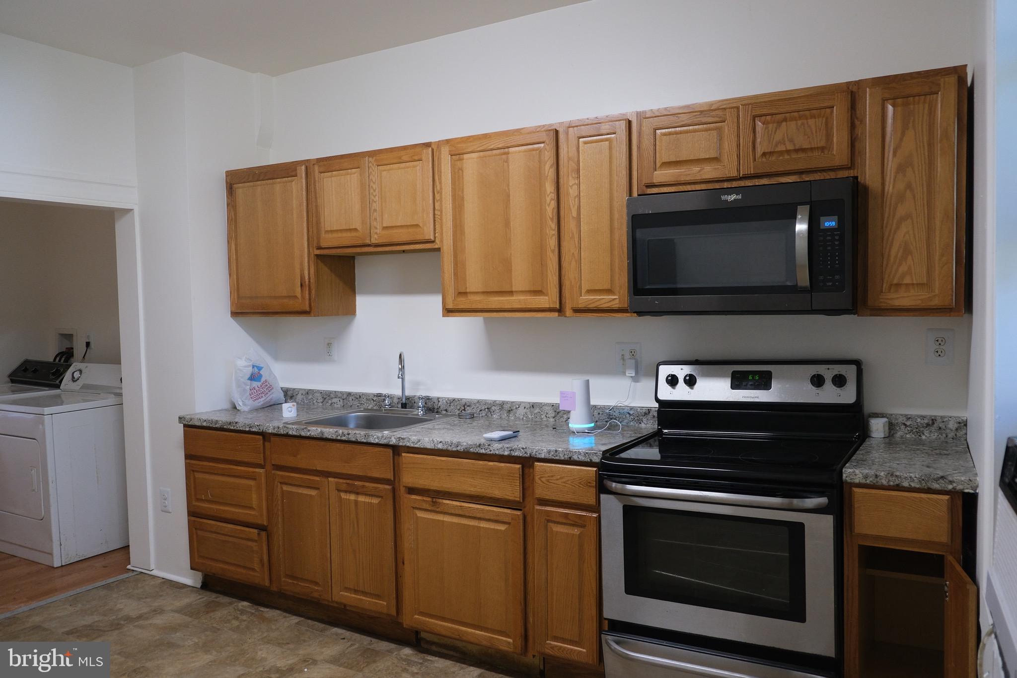 3316 West Belvedere Avenue Baltimore, MD 21215 - Photo 5 of 19 a kitchen with granite countertop a stove microwave and sink