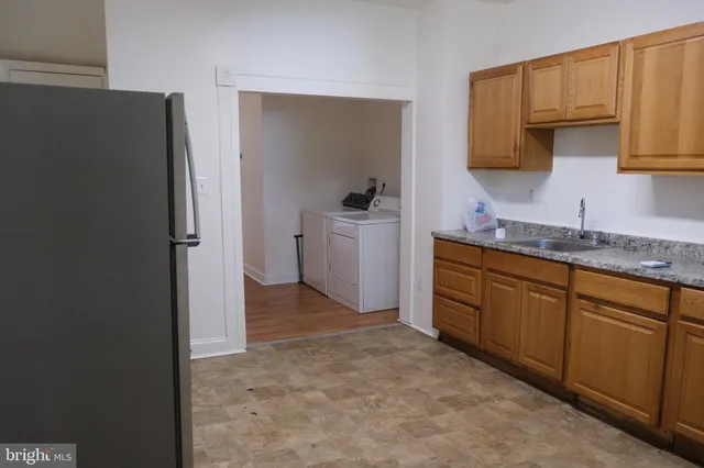 a view of a kitchen with sink electronic appliances and cabinets