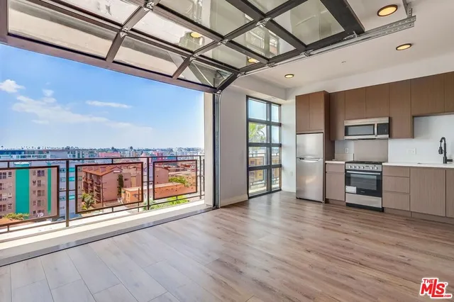 a view of a kitchen with refrigerator and wooden floor