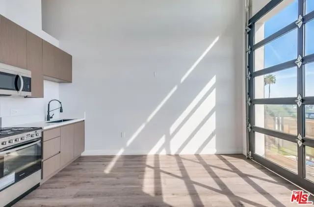 a view of a kitchen with a sink wooden floor and a window