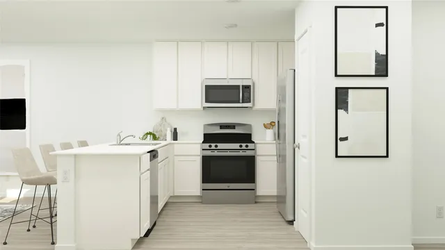 a kitchen with stainless steel appliances granite countertop a dining table chairs and a refrigerator
