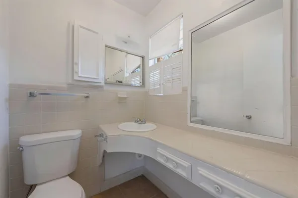 a bathroom with a toilet sink and mirror