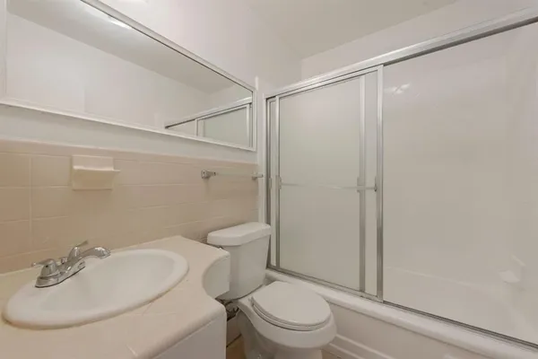 a white toilet sitting next to a bathroom sink