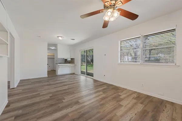 a view of a kitchen with a stove cabinets wooden floor and a ceiling fan