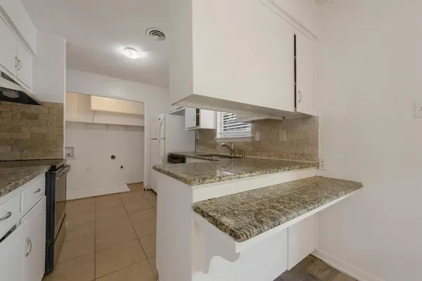 a kitchen with stainless steel appliances granite countertop a sink stove and cabinets
