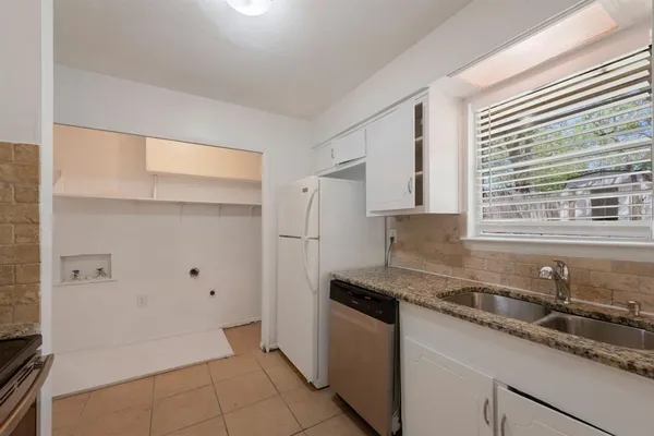 a kitchen that has a sink a stove and a refrigerator