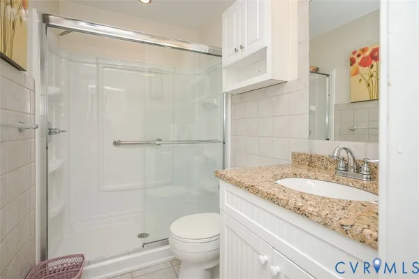 a bathroom with a granite countertop toilet a sink and a bathtub