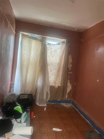 an empty room with wooden floor and a window