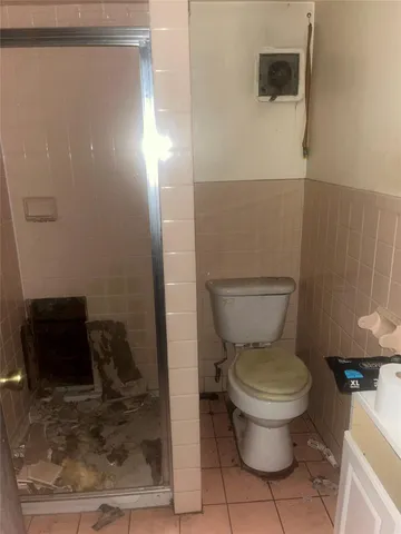 a bathroom with a toilet and a shower