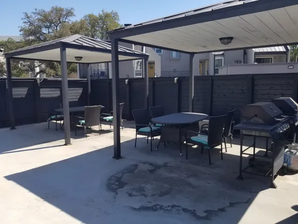 a view of a patio with a table and chairs under an umbrella
