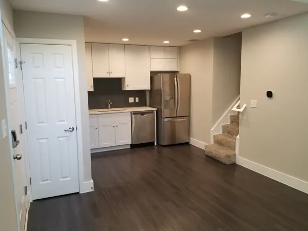 a kitchen with stainless steel appliances a refrigerator and wooden floor