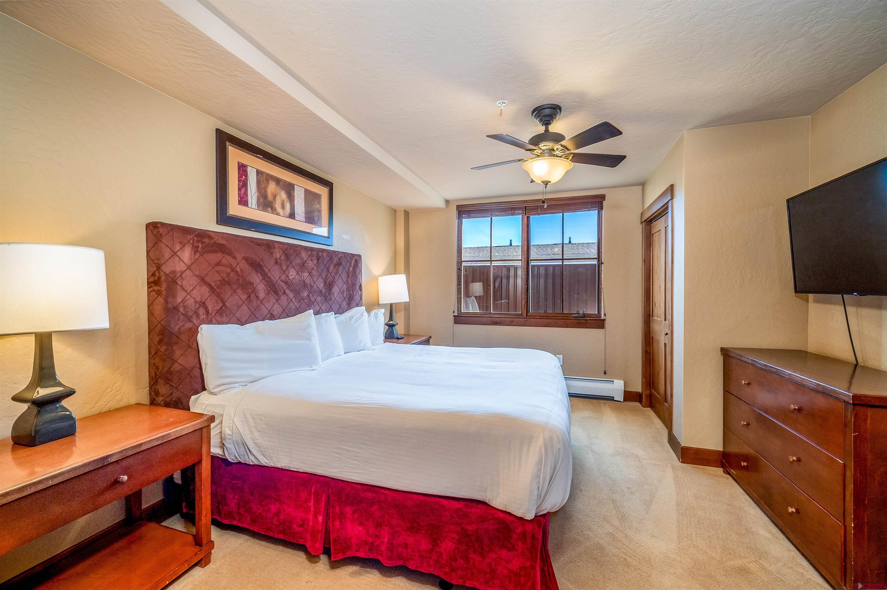 24 Sheol Street, Unit 205 Durango, CO 81301 - Photo 16 of 39 a bedroom with a large bed and a flat tv screen on dresser