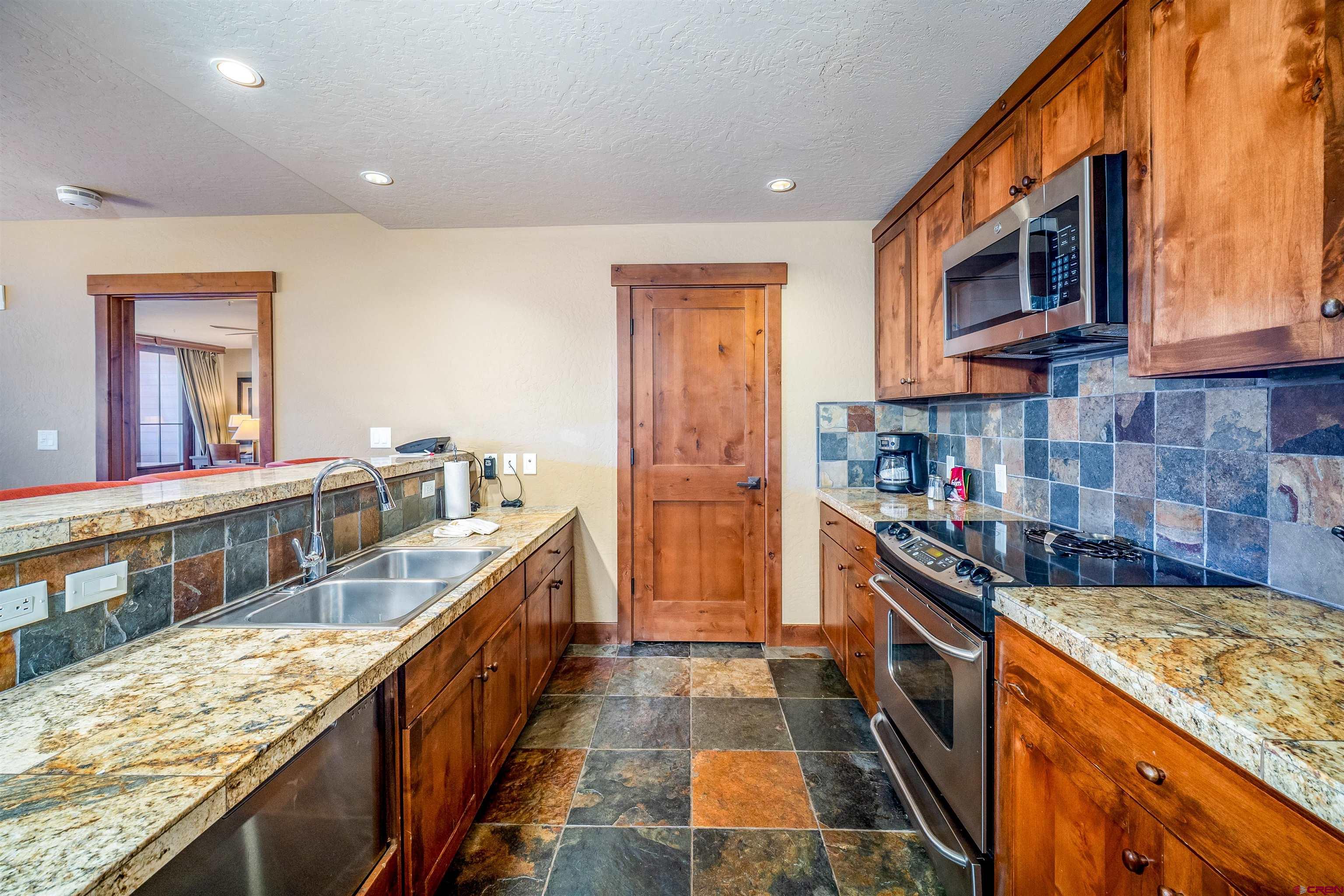 24 Sheol Street, Unit 205 Durango, CO 81301 - Photo 6 of 39 a kitchen with stainless steel appliances granite countertop a stove and a sink