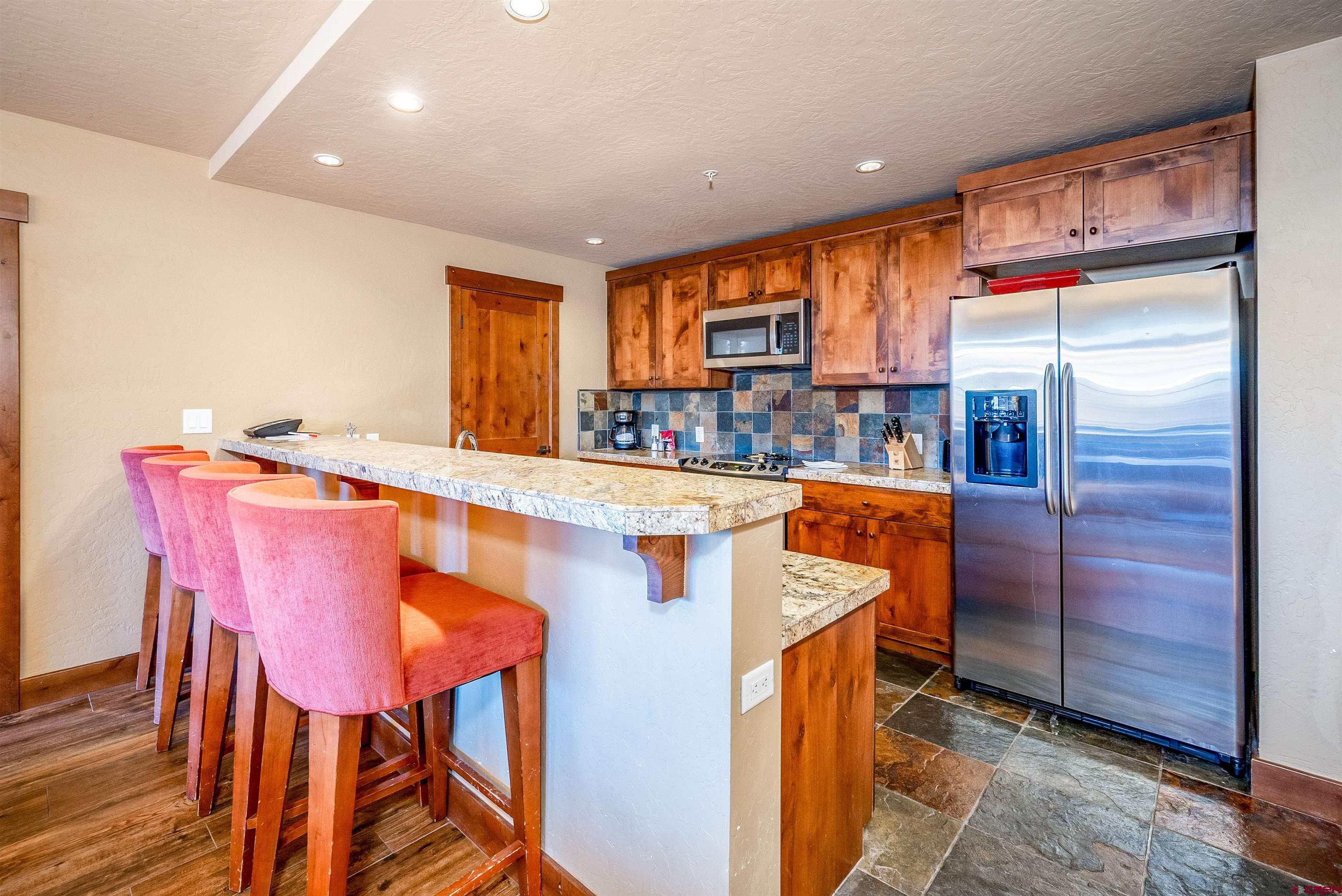 24 Sheol Street, Unit 205 Durango, CO 81301 - Photo 7 of 39 a kitchen with stainless steel appliances kitchen island granite countertop furniture and a refrigerator