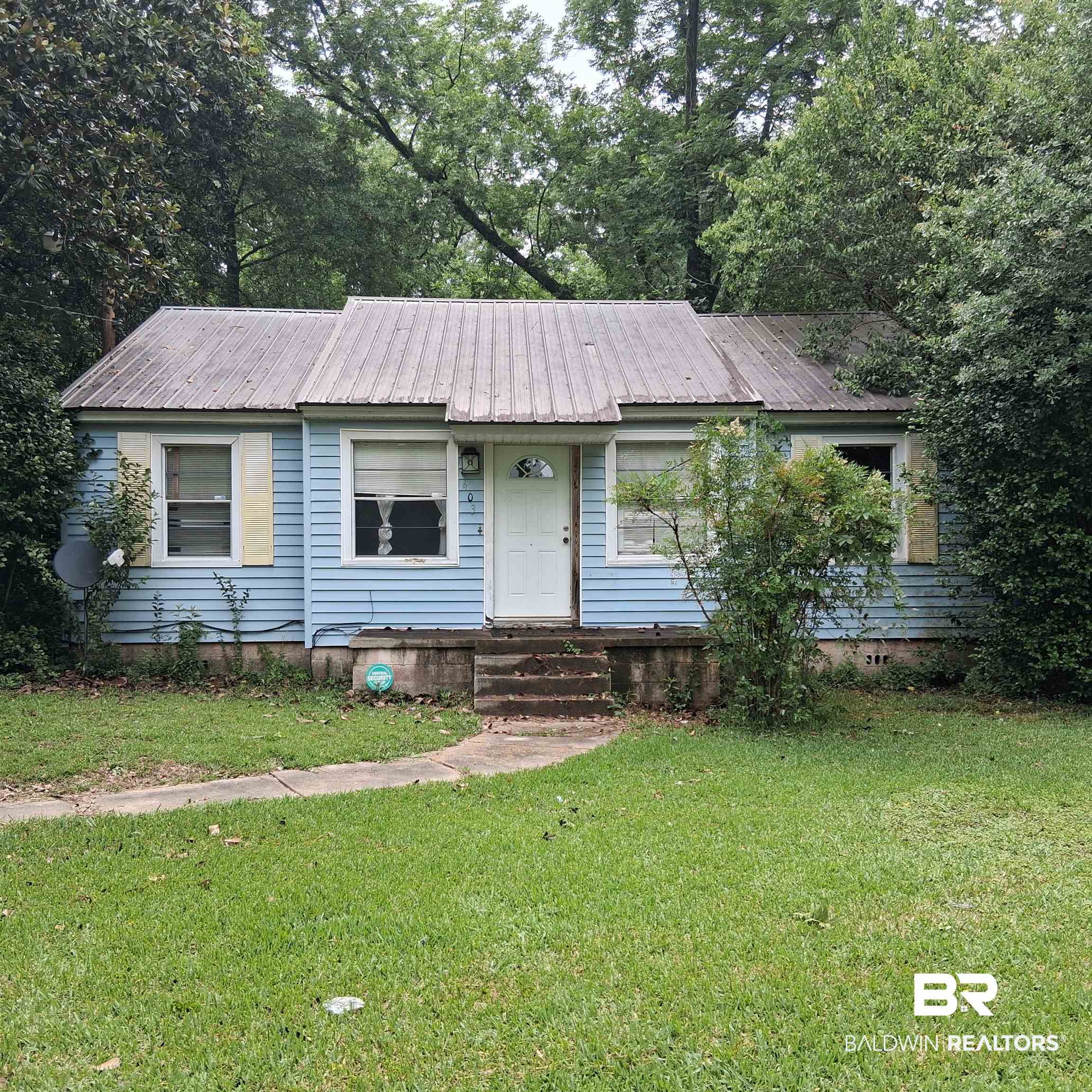 403 Bruner Avenue Evergreen, AL 36401 - Photo 1 of 9 Light blue siding exterior featuring a prominent metal roof