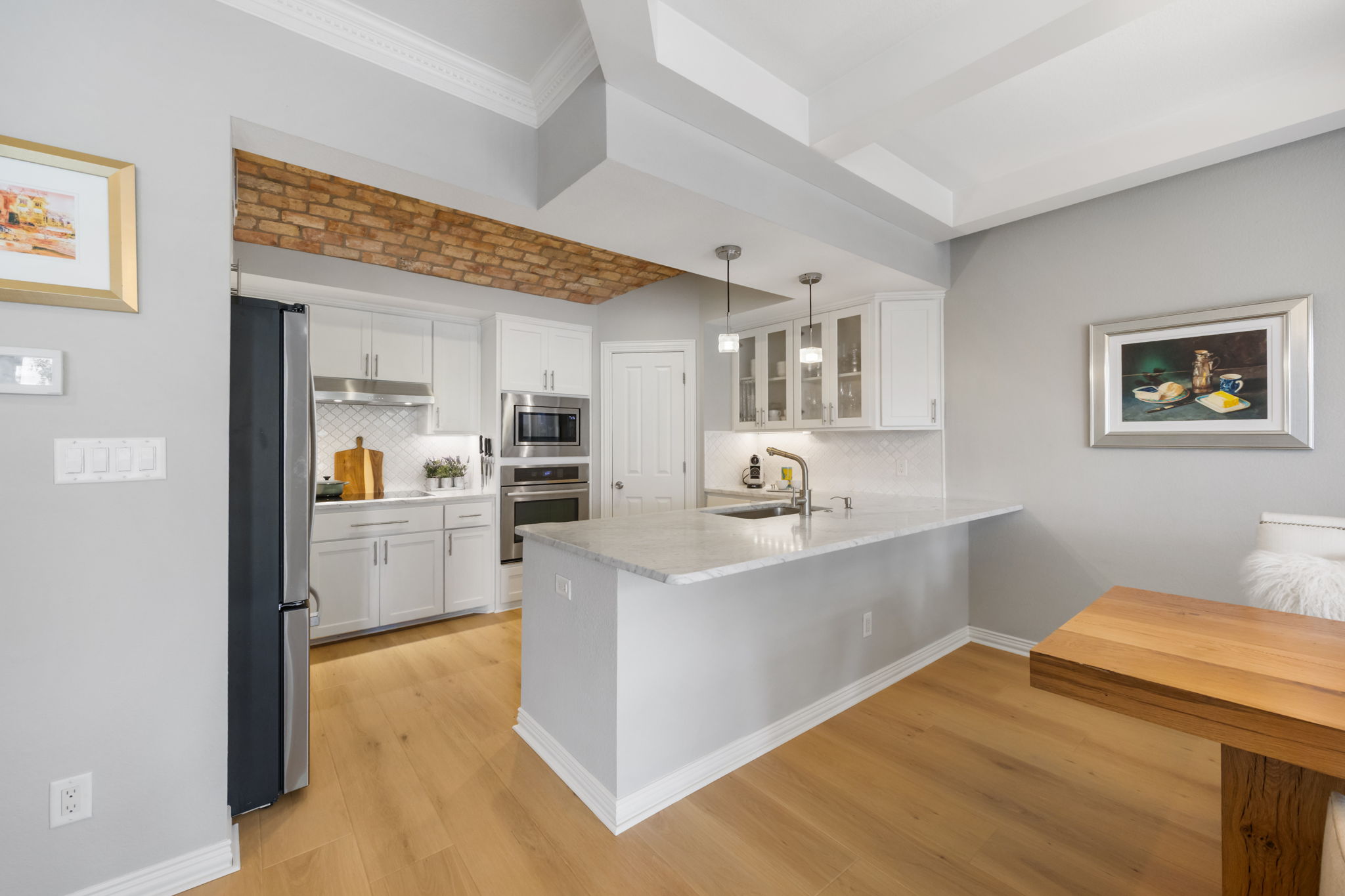 1910 Rue De St Tropez, Unit 6 Austin, TX 78746 - Photo 10 of 37 A well-appointed kitchen showcasing elegant cabinetry and a practical island, ideal for culinary creations.