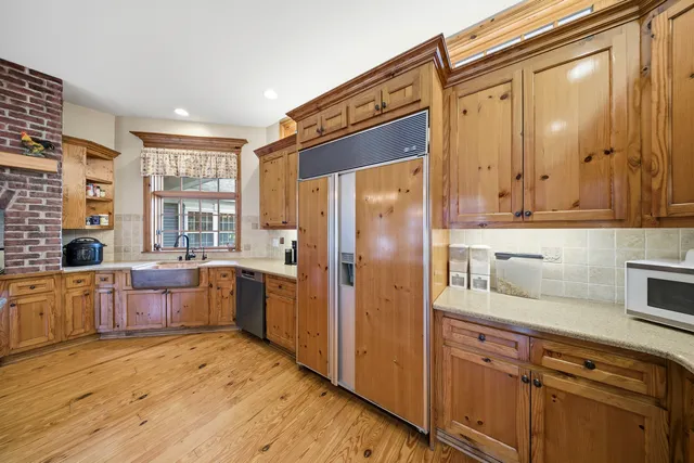 a large kitchen with a refrigerator a sink dishwasher stove and oven