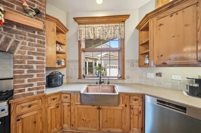 a kitchen with stainless steel appliances a sink a stove and a granite counter tops with a large window