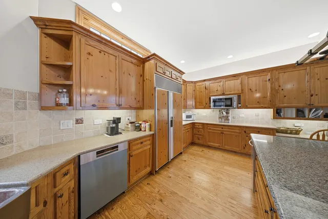 a large kitchen with stainless steel appliances lots of counter space and a sink