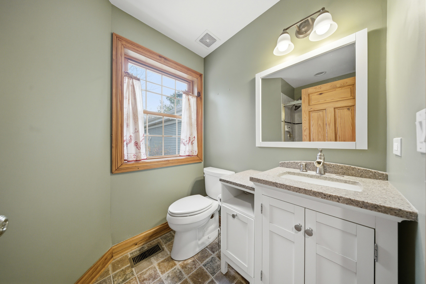 10731 Somonauk Road Hinckley, IL 60520 - Photo 26 of 48 a bathroom with a granite countertop sink mirror vanity and a toilet