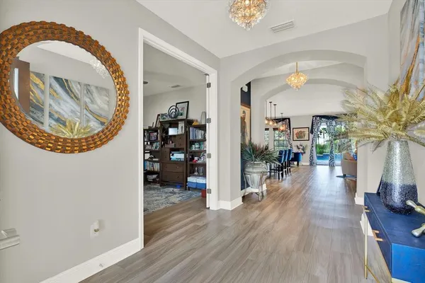 a view of a hallway with wooden floor and chandelier