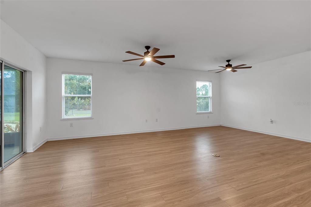 4322 Kiska Road North Port, FL 34288 - Photo 17 of 67 an empty room with wooden floor chandelier fan and windows