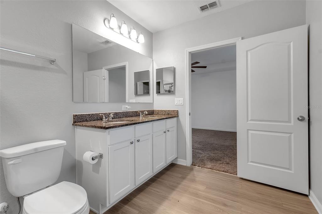 4322 Kiska Road North Port, FL 34288 - Photo 25 of 67 a bathroom with a granite countertop toilet sink and mirror