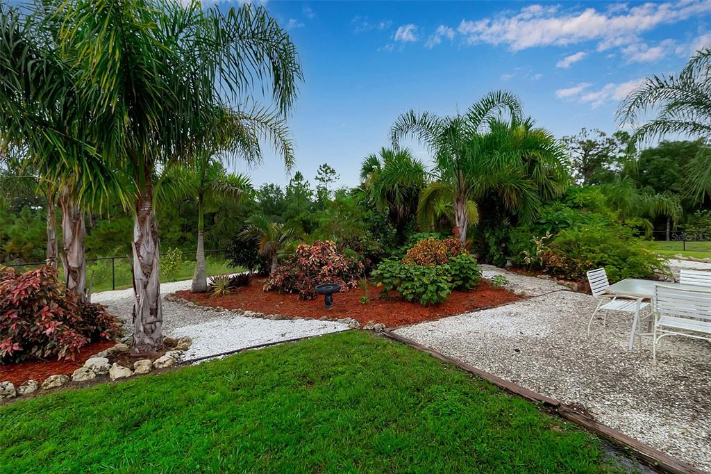 4322 Kiska Road North Port, FL 34288 - Photo 50 of 67 a view of a backyard with potted plants and palm trees