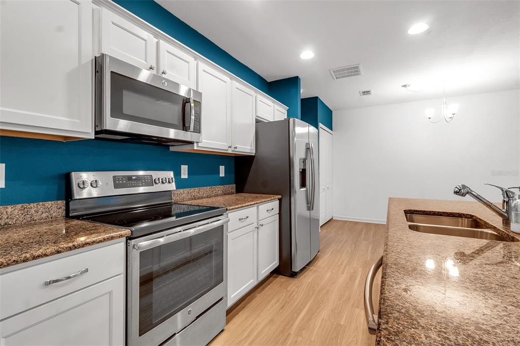 4322 Kiska Road North Port, FL 34288 - Photo 8 of 67 a kitchen with stainless steel appliances granite countertop a stove a microwave and a refrigerator