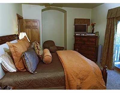 137 Knudson Ranch Road, Unit 137 Edwards, CO 81632 - Photo 6 of 8 a bedroom with furniture and a flat screen tv