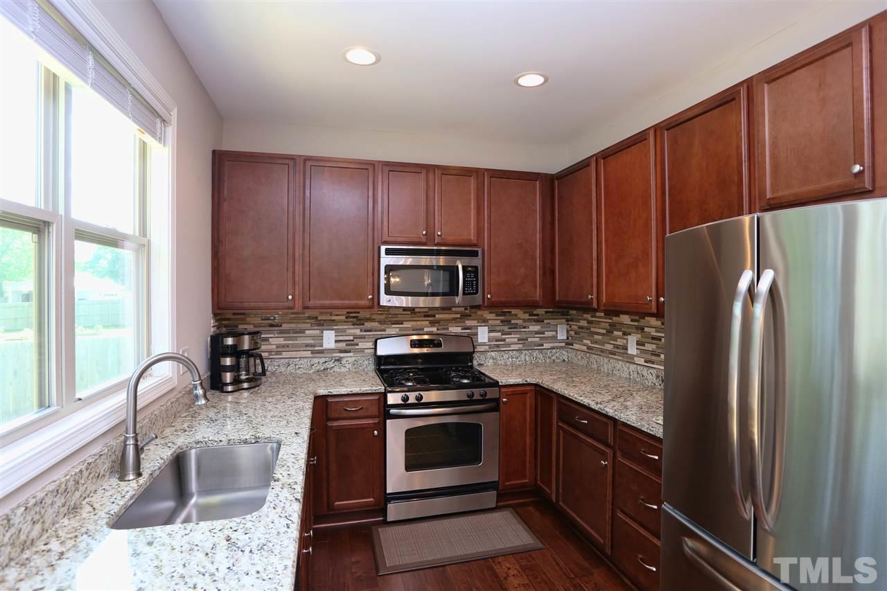 2310 Milburnie Road Raleigh, NC 27610 - Photo 4 of 25 a kitchen with granite countertop a refrigerator stove and sink