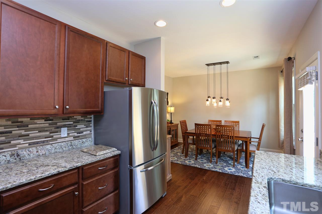 2310 Milburnie Road Raleigh, NC 27610 - Photo 5 of 25 a kitchen with stainless steel appliances granite countertop a refrigerator and wooden cabinets