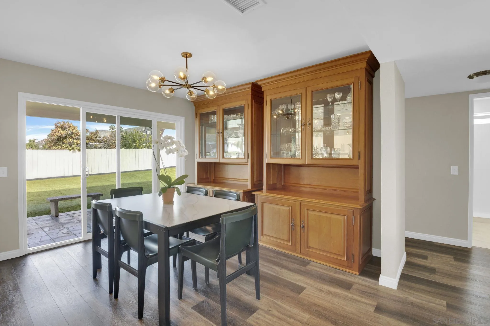 12408 Laja Drive Poway, CA 92064 - Photo 9 of 41 a dining room with wooden floor a chandelier a wooden table and chairs