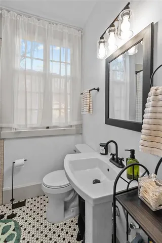 a bathroom with a sink a toilet and a mirror