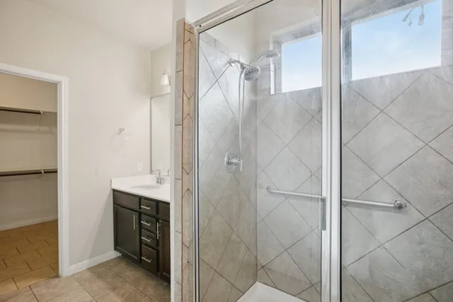 a bathroom with a shower sink and mirror