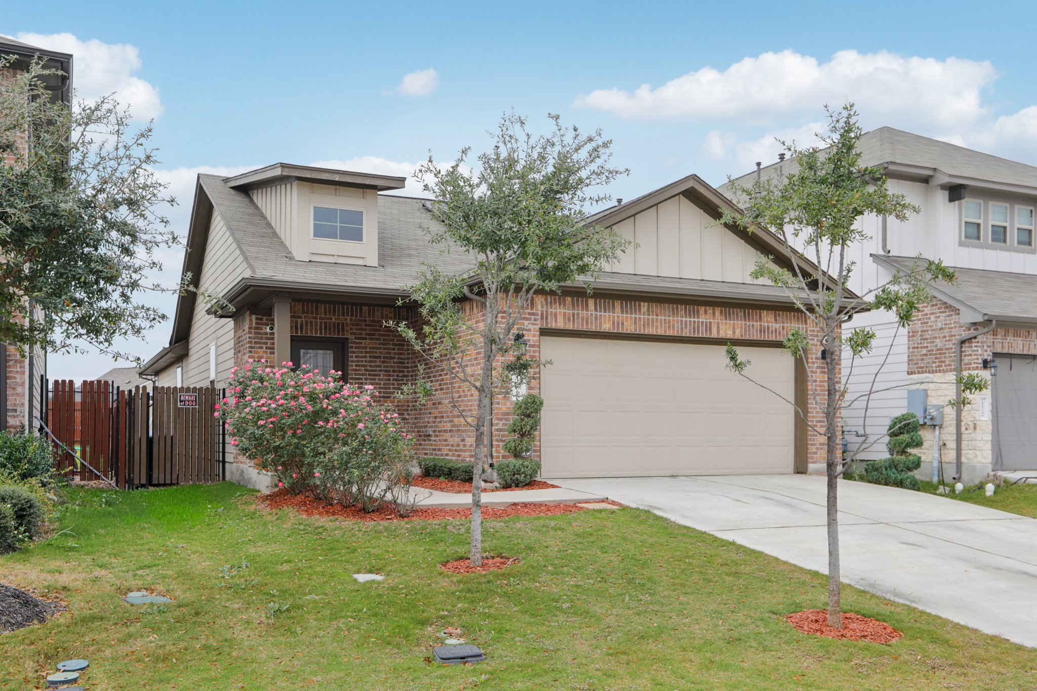 176 Mayney Ln. Leander, TX 78641 - Photo 2 of 37 View of front facade with concrete driveway, brick siding, an attached garage, and a shingled roof