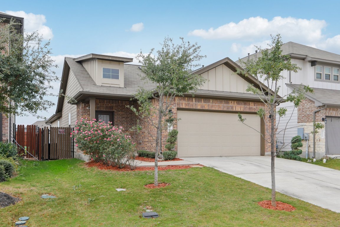 176 Mayney Ln. Leander, TX 78641 - Photo 2 of 34 View of front facade with concrete driveway, brick siding, an attached garage, and a shingled roof