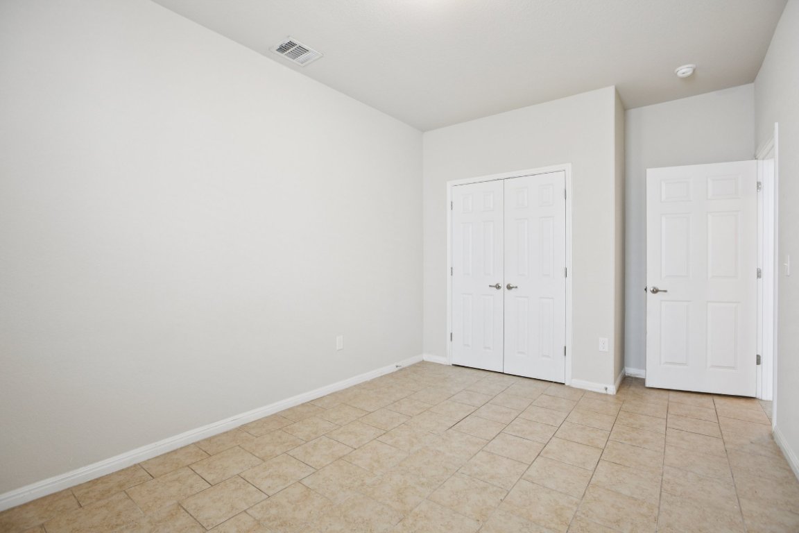 176 Mayney Ln. Leander, TX 78641 - Photo 25 of 34 Unfurnished bedroom featuring a closet and light tile patterned floors